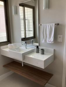 uma casa de banho com um lavatório branco e um espelho. em Flat reformado 1306 na Praia da Costa 1950 Edifício Ocean Flat em Vila Velha