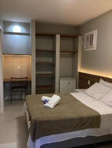 um quarto com uma cama com duas toalhas em Flat reformado 1306 na Praia da Costa 1950 Edifício Ocean Flat em Vila Velha