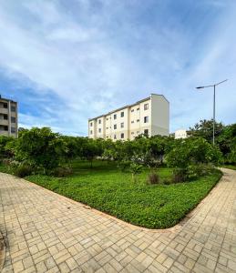 ein Gebäude mit einem gemauerten Gehweg vor einem Park in der Unterkunft Vipingo Palm Ridge Apartment - 406 in Mombasa