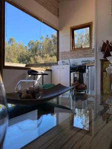 a kitchen with a glass table and a counter top at Cabaña La Quebrada Tunquen in Valparaíso +16 photos