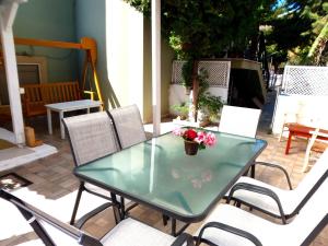 una mesa de cristal y sillas en un patio en Vacation_Studio_near_the_beach en Heraclión
