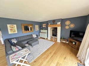 a living room with a couch and a fireplace at Ocean Retreat - Part of the The Bay Filey Holiday Village with pool, gym and direct beach access, pub, restaurant, tennis and meadows walks in Filey