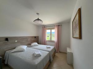a bedroom with two beds and a window at Résidence Casa Cintrone in Porto Pollo