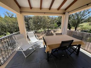 patio con mesa y sillas en el balcón en Résidence Casa Cintrone en Porto Pollo