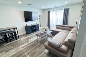 uma sala de estar com um sofá e uma televisão de ecrã plano em The Cozy Suite - 1BR with Free Parking em Paterson