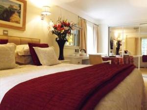 sypialnia z dużym łóżkiem i wazą kwiatów w obiekcie The Commodore Hotel w mieście Instow
