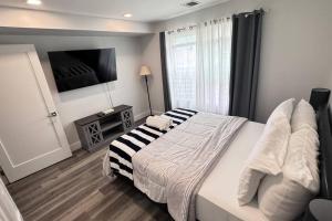 um quarto com uma cama e uma televisão na parede em The Cozy Suite - 1BR with Free Parking em Paterson