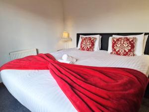 a bedroom with a large bed with a red blanket at Cleish 7 With Private Hot Tub - Fife - Loch Leven - Lomond Hills - Pet Friendly in Kelty