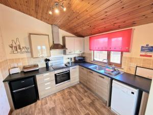 eine Küche mit einer schwarzen Arbeitsplatte und Holzdecken in der Unterkunft Cleish 7 With Private Hot Tub - Fife - Loch Leven - Lomond Hills - Pet Friendly in Kelty