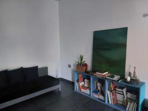 ein Wohnzimmer mit einem Sofa und einem Tisch mit Büchern in der Unterkunft The Green Blue House in Dar el Koudia