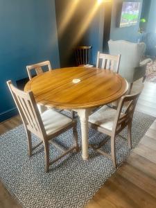 a wooden table with four chairs and a wooden table at Cosy Vibes Central Cardiff House in Cardiff