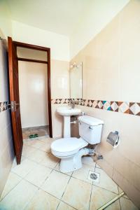 a bathroom with a toilet and a sink at JAMAKI Hospitality in Mombasa