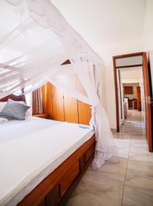 a bed with a canopy in a room at JAMAKI Hospitality in Mombasa