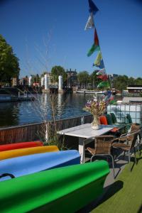 a table and chairs on a deck next to a river at FLOW in Amsterdam