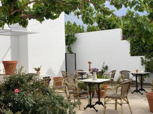 a patio with tables and chairs and plants at Les Filles (antiga Fonda de la Parra) in Deltebre