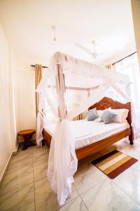 a bedroom with a bed with a mosquito net at JAMAKI Hospitality in Mombasa
