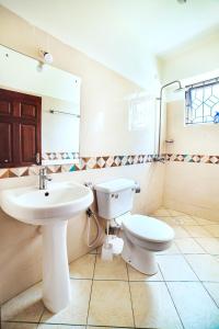 a bathroom with a toilet and a sink at JAMAKI Hospitality in Mombasa