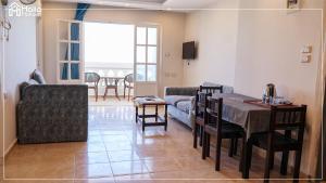uma sala de estar com uma mesa e um sofá em Halla Matrouh Sea View em Marsa Matruh