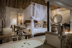 1 dormitorio con 1 cama y baño con bañera. en African Flair Boutique Safari Lodge en Hoedspruit