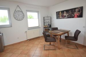 a dining room with a table and chairs and a clock at Bliss Place - 1R Premium Apartment - Kingsize Bett, Smart TV, Küche, Balkon, Waschkeller in Magdeburg