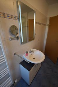 ein Bad mit einem Waschbecken und einem Spiegel in der Unterkunft Bliss Place - 1R Premium Apartment - Kingsize Bett, Smart TV, Küche, Balkon, Waschkeller in Magdeburg