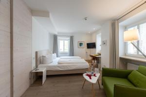 バイルングリースにあるFuchsbräuのベッドルーム(ベッド1台、緑のソファ付)