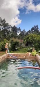 une femme et un homme dans une piscine dans l'établissement Guesthouse & Mini camping Yuccasa, à Pombal
