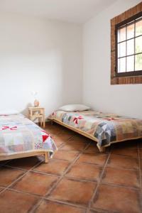 two beds in a room with a tiled floor at Ca la Terra in Vallespinosa