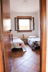 a room with two beds and a window at Ca la Terra in Vallespinosa