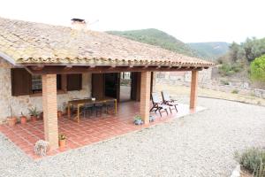 a house with a patio with a table and chairs at Ca la Terra in Vallespinosa