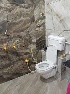 a bathroom with a toilet and a stone wall at Hotel Barsana Palace, Near Mahakal Temple- 200 meter in Ujjain