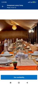 a long table with white plates and dishes on it at Authentic Desert Luxury Camp in Merzouga