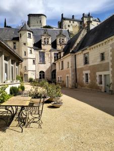 a courtyard with a table and chairs in front of a castle at Le logis de Bodard in Chinon