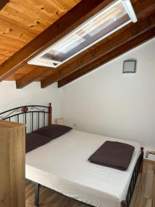 a bedroom with a white bed with a skylight at Stone House Istria HRIS 1 in Baderna