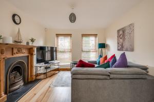 a living room with a couch and a television at Stylish & spacious 3 bedroom entire house in Lisburn with parking in Lisburn