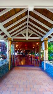 un patio con sillas y mesas en un restaurante en Sublime Tahiti Beach Retreat, en Mataiea
