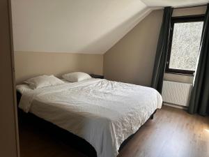 1 dormitorio con 1 cama con sábanas blancas y ventana en 3bdr Family Friendly Villa 15 min from Ullared en Älvsered