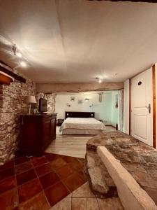 1 dormitorio con cama y pared de piedra en Les Balcons du Pastel, en Puylaurens