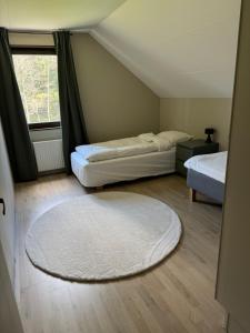 a bedroom with two beds and a rug on the floor at Hus med 3 sovrum i lugn miljö nära natur & Ullared in Älvsered