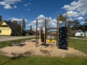 um parque infantil vazio num parque com um banco em Family Friendly Villa 15 min from Ullared em Älvsered