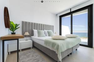 a bedroom with a large bed and a large window at Apartament Infinity View in Arenales del Sol +25 photos