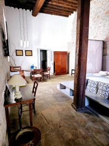 a room with a bed and a table and chairs at Keresbino Hydra Manor House in Hydra