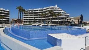 a large swimming pool in front of a large building at Apartament Infinity View in Arenales del Sol