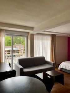 een woonkamer met een bank en een bed bij Résidence Le Grand Tétras- SPA THERMAL INCLUS in Ax-les-Thermes