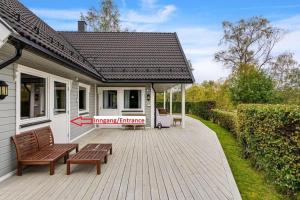 een huis met twee banken op een houten terras bij Glomma House in Kongsvinger