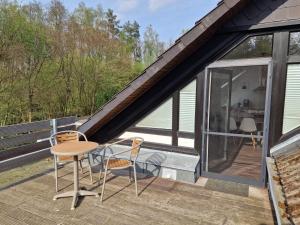 una casa con balcón con mesa y sillas en Ferienwohnung in der Heide en Faßberg