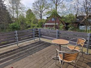 una terraza de madera con mesa y sillas. en Ferienwohnung in der Heide, en Faßberg