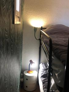 a bedroom with a bed and a lamp on a night stand at Studio cabine GRUISSAN PLAGE DU GRAZEL in Gruissan +4 photos