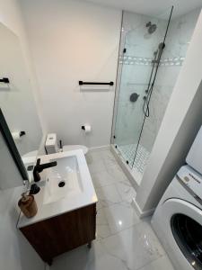baño blanco con ducha y lavamanos en Perrin Place Unit 1, en Boston