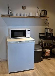 un forno a microonde in cima a un frigorifero in una cucina di Glomma House a Kongsvinger